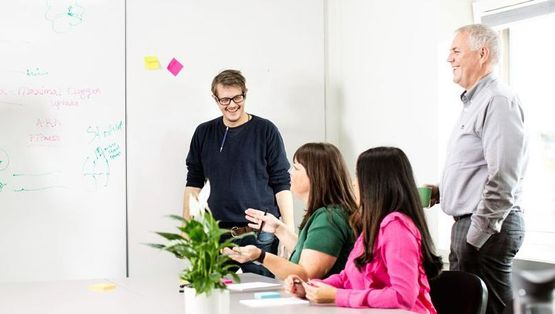 kvinne smiler skriver på post it lapper 