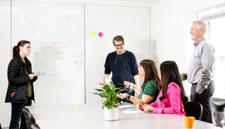 kvinne smiler skriver på post it lapper 