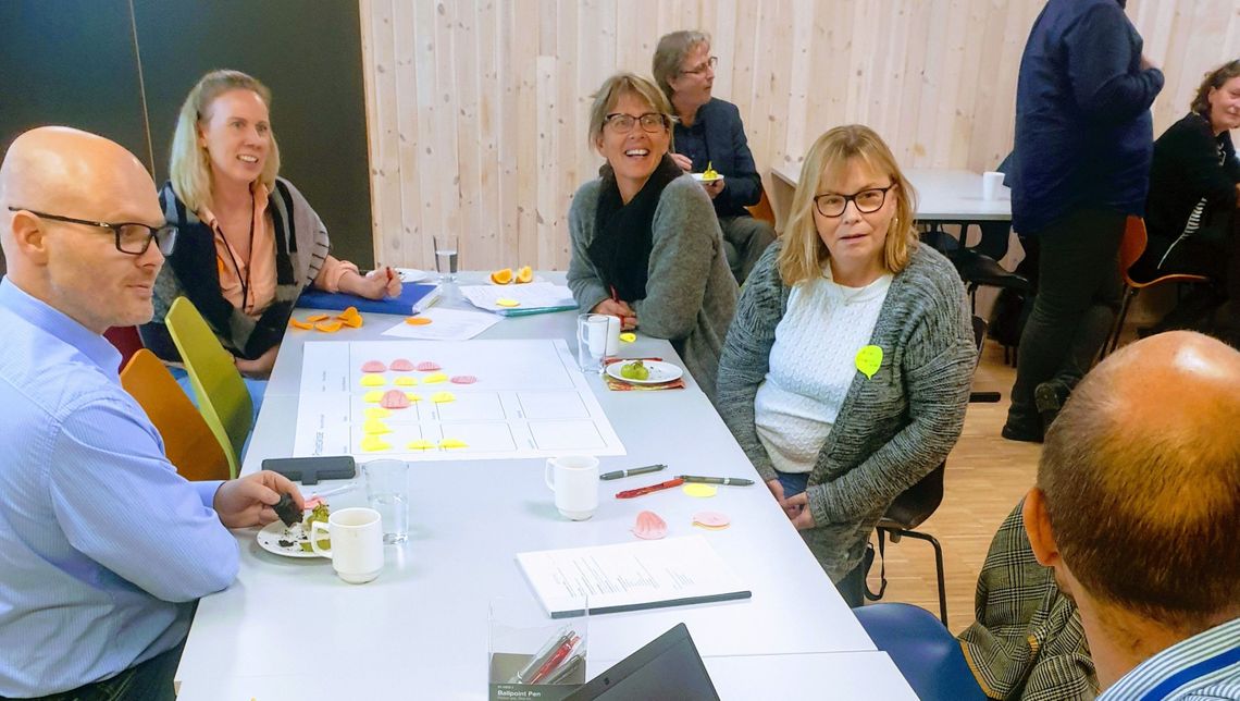 people aoround a table discussing in a workshop