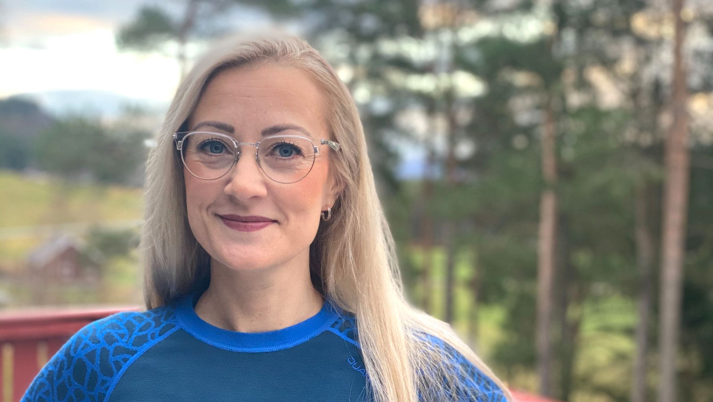 kvinne med utsikt bak som smiler