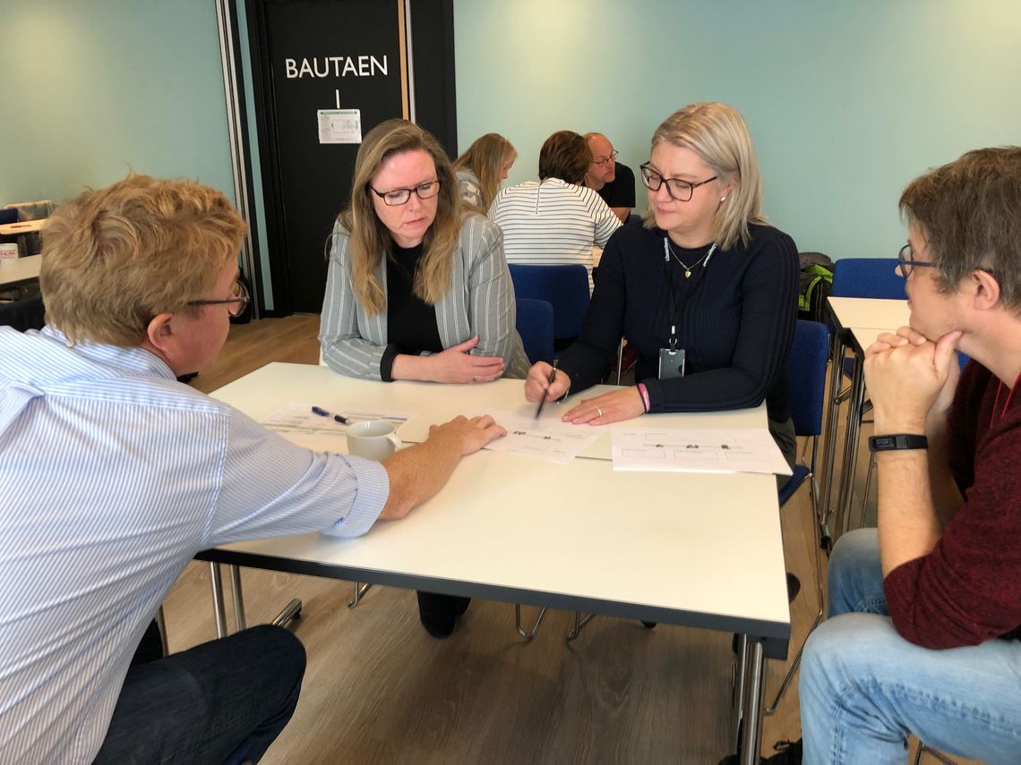 gruppearbeid innovasjonsseminar folk snakker sammen rundt bordet 